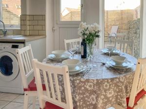 a dining room table with chairs and a table with plates and flowers at Holmfield in Buxton