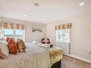 a bedroom with a bed and two windows at The Farm House in Elston +18 photos