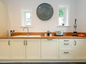a kitchen with a sink and a clock on the wall at Langford Villa in Filey
