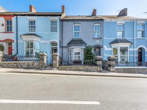 a row of blue houses on the side of a street at Nelson Cottage in Tenby