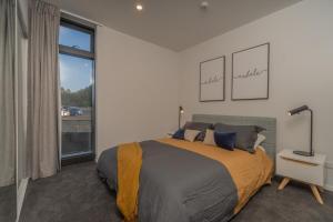 a bedroom with a bed and a large window at High End Centrally located apartment with carpark in Auckland