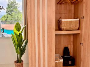 une plante dans une armoire en bois à côté d'une fenêtre dans l'établissement Lavoe Boutique Hotel, à Koh Samui 
