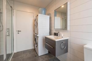 a bathroom with a washing machine and a sink at High End Centrally located apartment with carpark in Auckland +29 photos