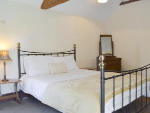 ein Schlafzimmer mit einem Bett und einem Spiegel an der Wand in der Unterkunft Burdettes Cottage - 25349 in Findern