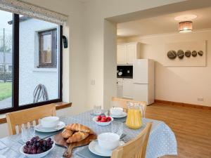 una sala da pranzo con un tavolo con del cibo sopra di Shellhill Cottage a Kirkcudbright