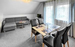 un salon avec une table, des chaises et un canapé dans l'établissement Ferienwohnung Trassenheide, à Trassenheide