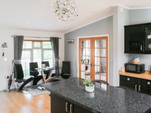 Una cocina y una sala de estar con mesa y sillas. en Stag Lodge, en Auchterarder