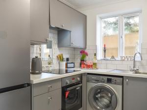 a white kitchen with a washer and dryer at Apartment 1 - Uk42622 in Poole