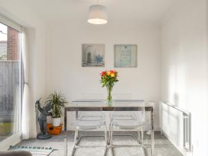 a dining room table with a vase of flowers on it at Apartment 1 - Uk42622 in Poole