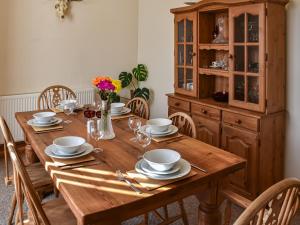 a wooden table with chairs and a wooden cabinet at St Judes in Mundesley