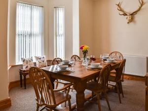 a dining room with a wooden table and chairs at St Judes in Mundesley