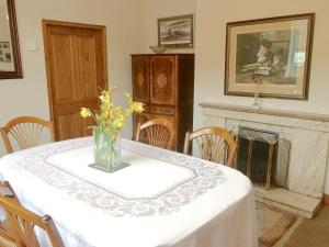 a table with a vase of flowers on it with a fireplace at Station House - Hw7742 in Glyn-Dyfrdwy
