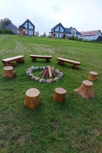 a group of logs and benches in a field at Domki Baby Jagi in Krajno Pierwsze +2 photos