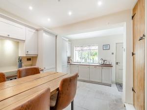 una cucina con tavolo e sedie in legno di Cherry Blossom Cottage a Etton