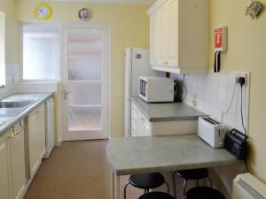 a kitchen with white cabinets and a counter with stools at Trevina in Portland