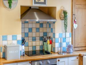 a kitchen with a tile counter top with a hood at Stamford Townhouse in Stamford