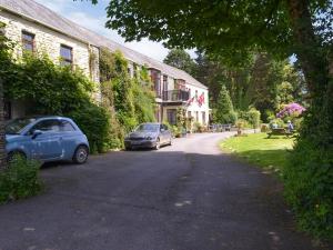 two cars parked on a street next to a building at Mill Apartment - Ukc3784 in West Down