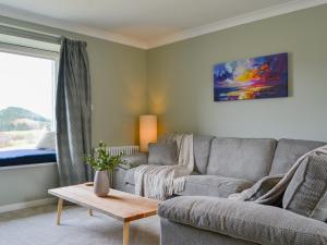 a living room with a couch and a table at The Grain Store in Aberarder