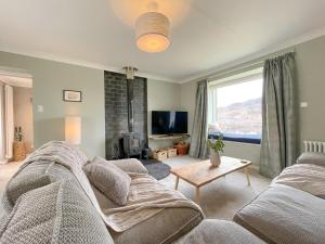 a living room with a couch and a tv at The Grain Store in Aberarder