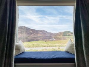 a window with a view of a mountain view at The Grain Store in Aberarder