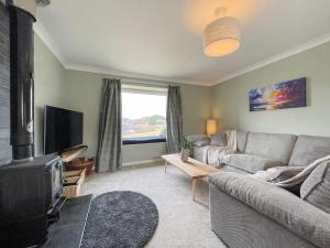 a living room with a couch and a tv at The Grain Store in Aberarder