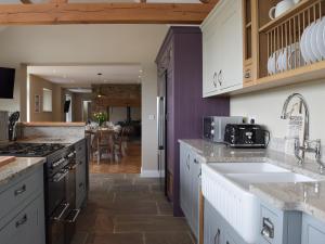 a kitchen with white cabinets and a sink at Trecift in Cardigan
