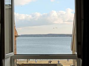 a view of a beach from a window at Sea Blue Cottage in Scarborough