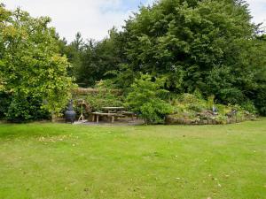 a picnic table in a yard with trees and grass at The Shippon in Burscough