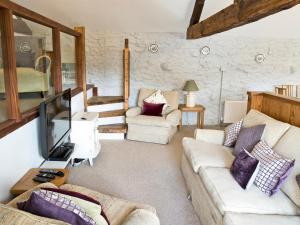 a living room with a couch and a tv at Lavender Cottage - Uk4061 in Buxton