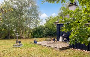 a cabin with a wooden deck in a yard at Cozy Home In Vejby With Wifi in Rågeleje