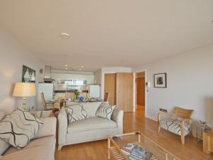 Una sala de estar con dos sofás y una cocina. en Sea Side, en Westward Ho