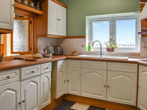 a kitchen with white cabinets and a sink at The Boat House in Canterbury +27 photos