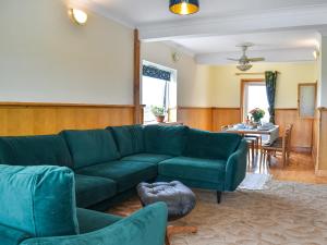 a living room with a green couch and a table at The Boat House in Canterbury