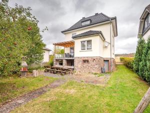 a large white house with a bench in the yard at Spacious Villa near Center in Medebach