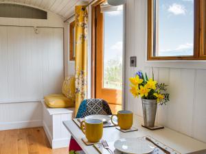 a small kitchen with a table and yellow flowers at Ty Olwyn Bach - Uk36418 in Talybont