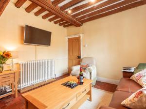 a living room with a couch and a table at Pollard Cottage in Lingfield