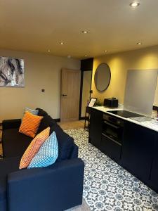 a living room with a blue couch and a counter at The Goodrington Sands- Apart Hotel in Paignton