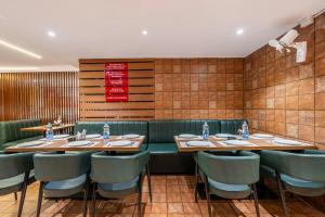 a dining room with tables and green chairs at Treebo Comfy Business in Bengaluru