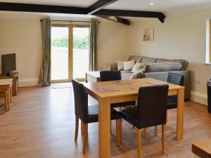 a living room with a table and chairs and a couch at Horseshoe Cottage in Alkham