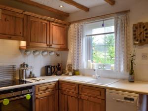 a kitchen with a sink and a window at Haagwood Cottage in Cretshengan