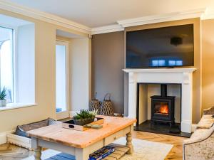 a living room with a fireplace with a tv above it at Hazelrigg in Bowness-on-Windermere