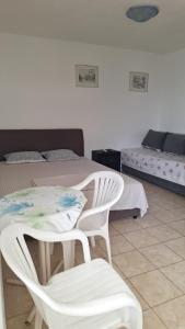 Un dormitorio con una cama y una mesa y sillas. en Studio Jupi, en Pržno