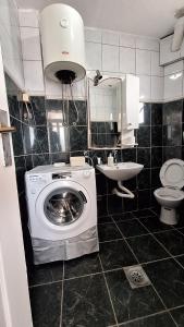 Un baño con lavadora y lavabo. en Studio Jupi, en Pržno