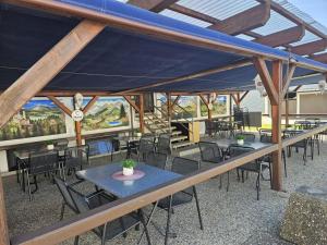 Eine Gruppe von Tischen und Stühlen unter einem Zelt in der Unterkunft Hotel - Restaurant Baumann in Freiberg am Neckar