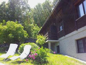 two white chairs in the yard of a house at Holiday Home Vesenjak in Maribor