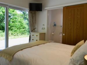 ein Schlafzimmer mit einem Bett und einer Glasschiebetür in der Unterkunft Hidden Gem in Berrynarbor + 16 Fotos