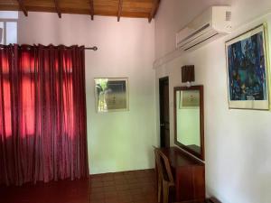Una habitación con un espejo, una cómoda y un televisor. en Guruge Villa Habarana, en Sigiriya