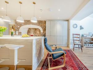a kitchen with a large island with a blue chair at The Anchorage in Pembroke +32 photos