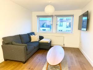 a living room with a couch and a table at Cosy apartment near Edinburgh city centre in Edinburgh