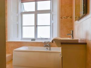 a bathroom with a tub and a sink and a window at Uk47786 - Flat 4E in Aberystwyth